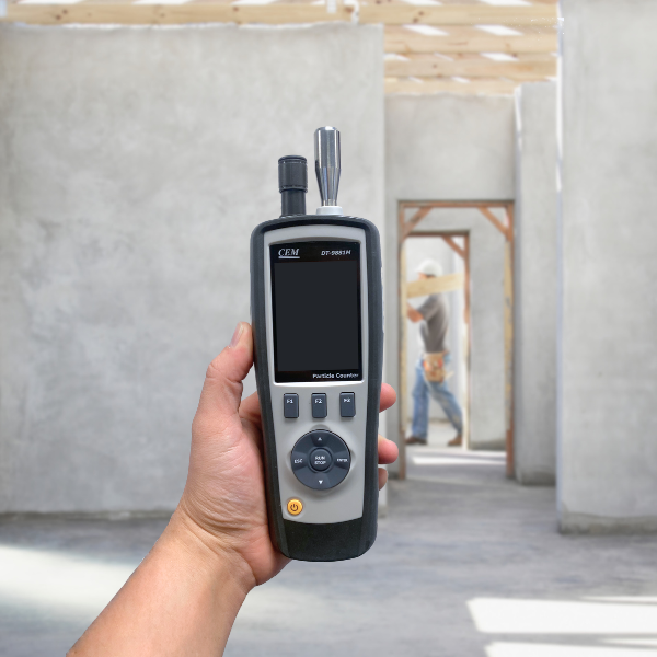 An image of the CEM DT-9881M Particle Counter held up in a construction site.